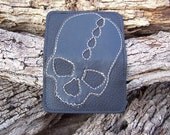 Black skull stitched on black leather wallet