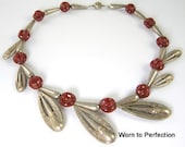 Ethnic Boho Necklace in silvertone with carnelian colored glass balls. This piece definitely has some age. There is some wear to the silvertone finish that is exaggerated in my close up photos. Overall length is 16-5/8 inches. Front and back look exactly the same. Large barrel clasp is strong and secure. I love how the teardrop shaped pieces are set on angles to create beautiful movement in this necklace. In good condition. Very pretty. Unsigned.