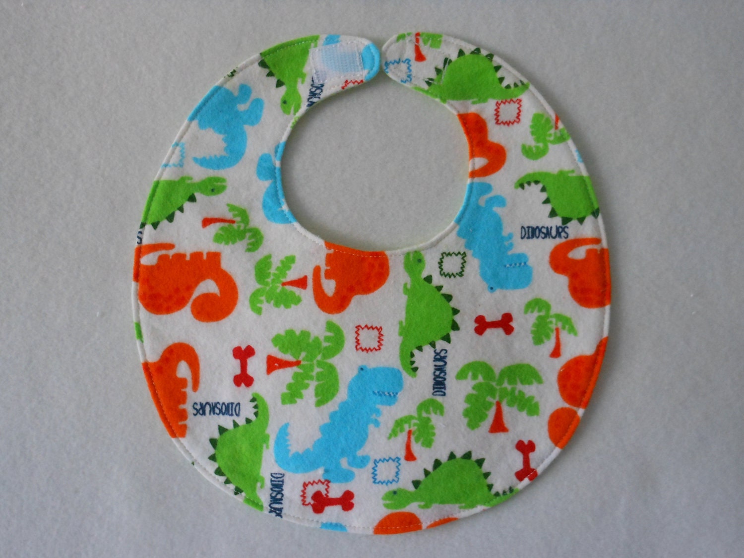 Baby Bibs, four soft layers, reversible, white with bright blue, green, and orange dinos