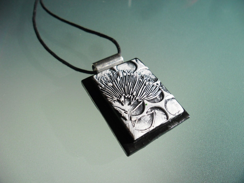 Polymer clay pendant featuring wild flower