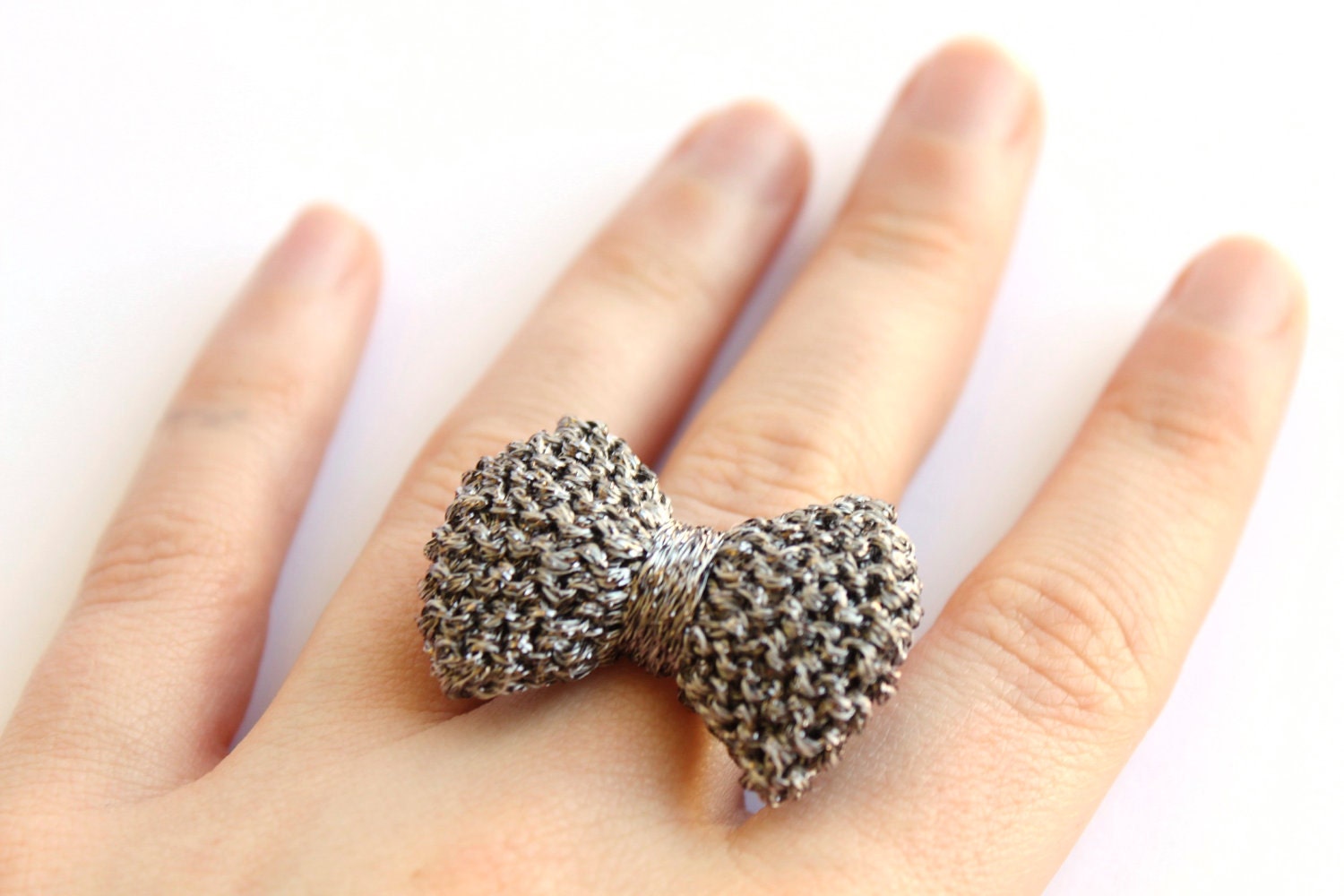 Bow ring knitted in gun metal grey, silver ring