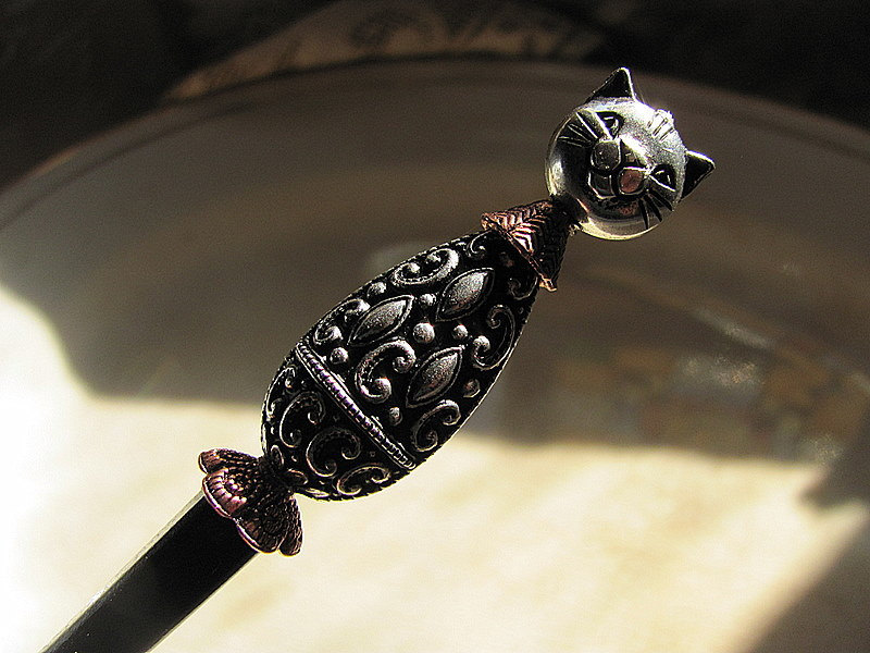 A cat-shaped hair pin in black lacquer