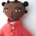 black girl doll in pink coat