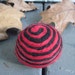 One multi-colored felted pin-cushion, Red and Black