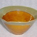 Wheel thrown pottery serving bowl with scalloped rim in amber and sage green