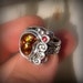 Favor of Kane Fire agate set in a sterling silver handcrafted ring with Red garnet accent stone