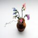 Miniature sweetpeas in a turned wooden vase.