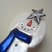 Snowman holding a star with blue scarf pin brooch