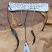 Rawhide leather wall hanging shield with feather, fur, bone, spine, and quote