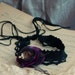 Black choker with flower brooch in black, brown and purple.