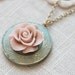 Weathered vintage style locket necklace. Antique blue with a pale pink blooming rose.
