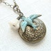 Whimsical vintage style locket necklace. Antique brass locket with a glass bead and verdigris patina sparrow. Jewelry by Sweet And Simple.