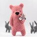 A pink bear brooch with pearls in paw