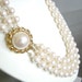 Vintage triple strand cream faux pearl necklace with gold chain clasp