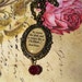 Bram Stoker Quote Necklace - "In trance she is Un-Dead", In oval bronze setting beneath resin, blood red accent bead