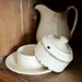 vintage enamelware covered butter dish with lid, cream with gold pin striping, from the Netherlands