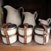 vintage enamelware canisters, 3 small tins with leather straps, white with gold striping from Germany