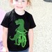 Toddler DINOSAUR t rex on bike T-Shirt (Sizes 2-12)