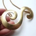 Statement jewelry. Large gold necklace with vintage brass flourish.