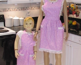 MOTHER DAUGHTER APRON set in a mauve, lavender print, retro style with shawl collor,two pockets,embroided ribbon and lace