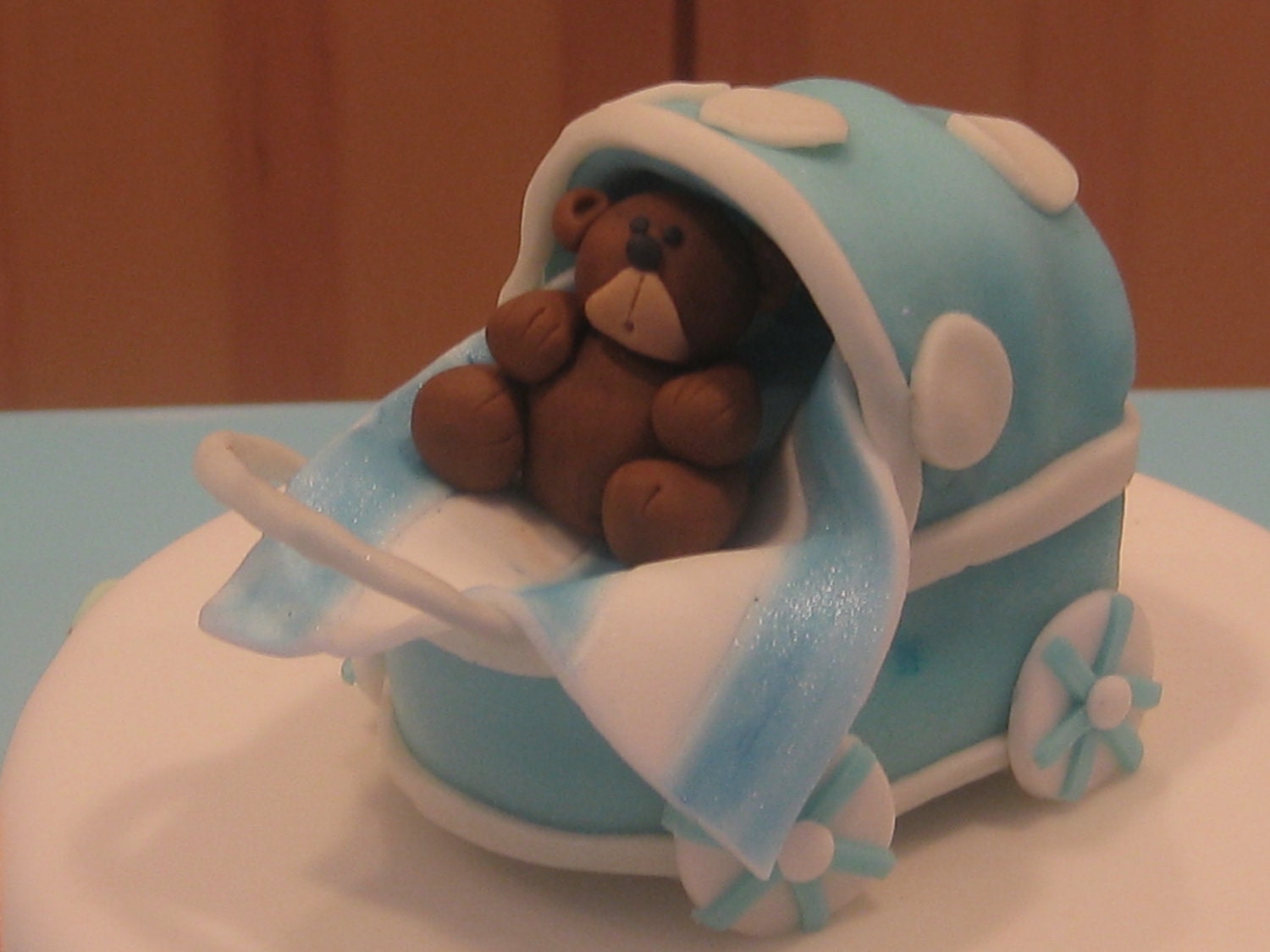 Edible fondant blue baby stroller/carriage cake topper.