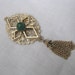 Peking pin brooch with tassel by Sarah Coventry Gold tone w/ green