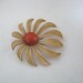 Light tan pinwheel enamel flower pin brooch with orange center
