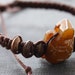 Woven bracelet in brown cotton cord with turtle bead