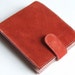 Orange suede billfold wallet with 'bookshelves' print lining