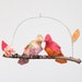 Little lovebird steals a kiss - fabric mobile on yarn wrapped branch in tangerine orange, cherry pink, and a touch of white