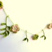 Spring crocheted flower garland, home decoration with flowers and leaves green, pink