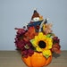 Pumpkin centerpiece , scarecrow, sunflowers, mums, leaves, berries and ribbon