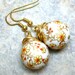 Orange flower on white background Tensha beads gold tone earrings