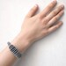 minimalistic geometric bracelet with grey circles and yellow beads