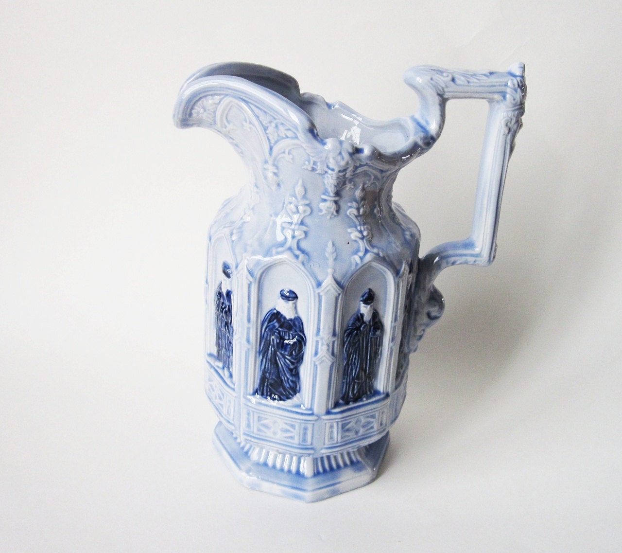 Unusual Embossed Blue Ceramic Pitcher with Bas Relief Figures