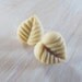 A pair of creamy beige leaf post earrings
