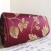 burgundy and gold clutch bag