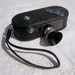 Movie camera Keystone 8mm model K-8, black, shroud, leather strap, a vintage icon of home video movies, vacation resort travel adventure.