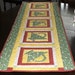 Quilted table runner chicks, ducks and baskets reversible in yellow, greens, pinks and cream