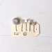 Five white vintage button hairslides on luggage tags