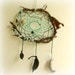 Baby mobile earth art magical dream catcher weaved in 2 shades of green with black pods and spotted feathers.