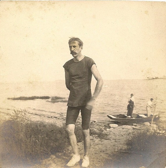 Early 1900's photo .Man in swimsuit walking from beach