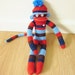 Striped sock monkey plush doll with hat - red, blue, and brown