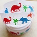 Primary colored prehistoric dinosaurs on white 7/8 inch grosgrain ribbon
