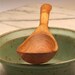 Small wooden stirring spoon with straight handle carved from Mesquite