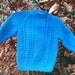 Childs boy's girl toddler blue aran cable sweater with back neck buttons.