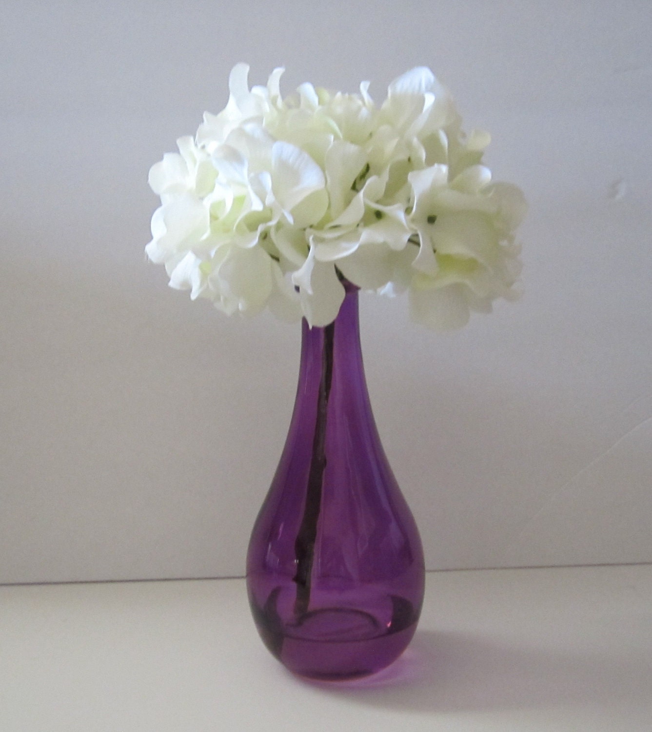 Floral Arrangement In 8 Inch Purple Vase With A Single White