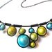 Wire wrapped necklace with pastel green and turquoise miracle beads, black wire and adjustable chain.