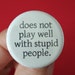 does not play well with stupid people. 1.25 inch button. Your frustration is not your fault. You are surrounded by idiots.