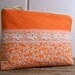 Cosmetic bag in happy orange with vintage lace.